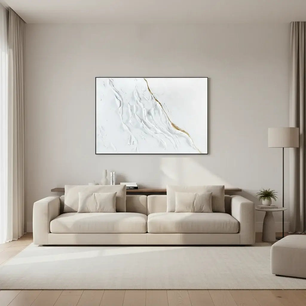 Modern living room with a beige sofa, abstract art on the wall, and a lamp.