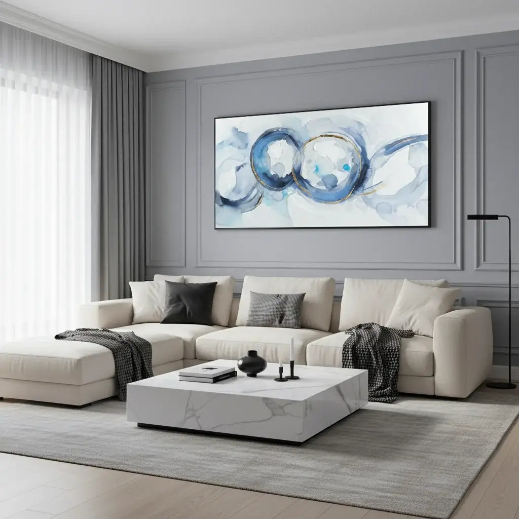 Modern living room with a beige sectional sofa, marble coffee table, and abstract wall art.