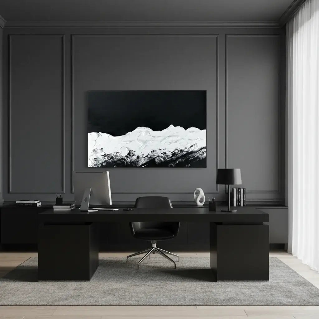 Modern office setup with a black desk, chair, and wall art.