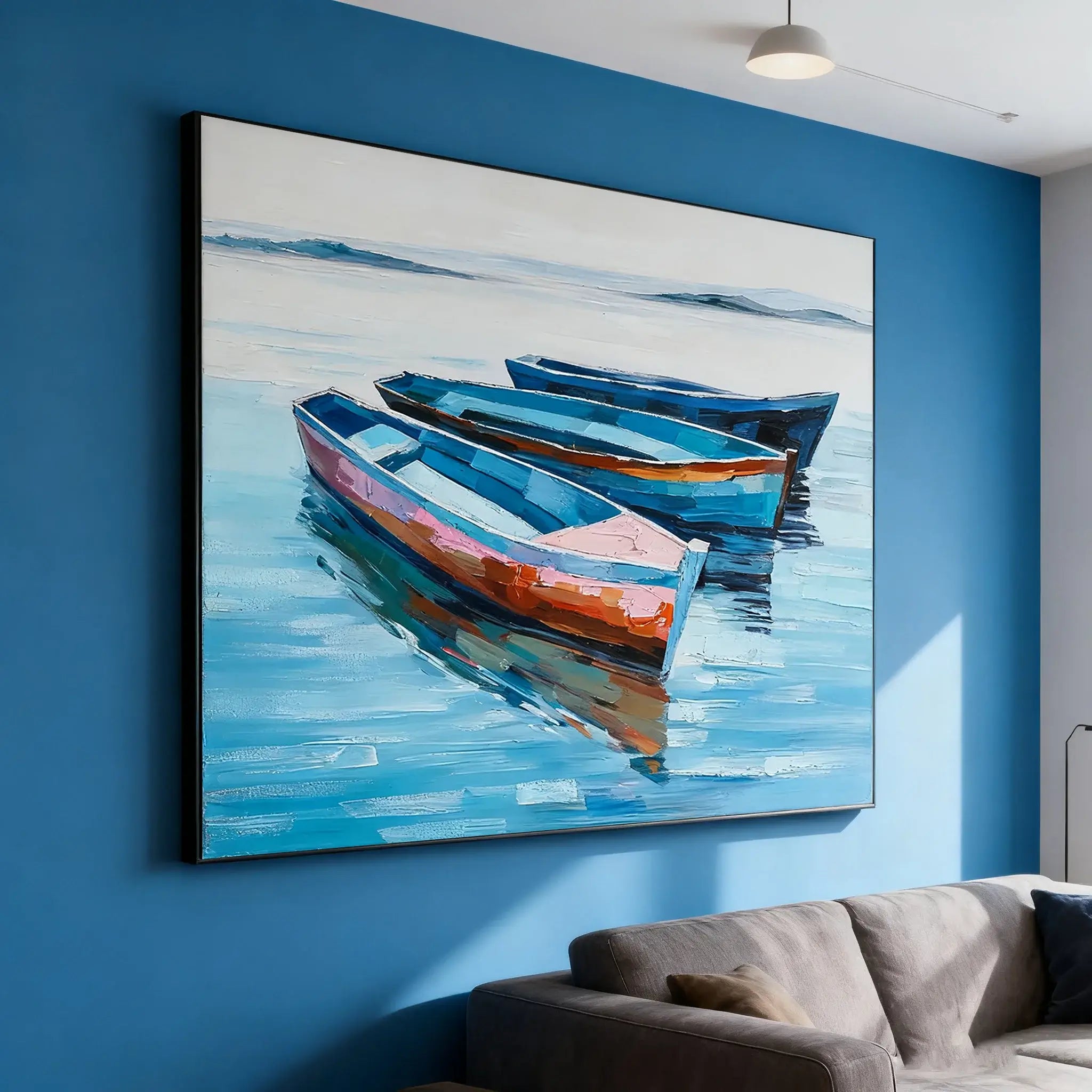 Painting of three boats on a blue wall above a sofa