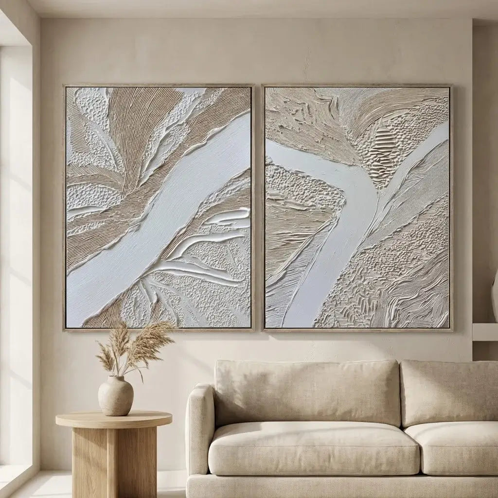 Two abstract wall art pieces above a beige sofa in a living room.