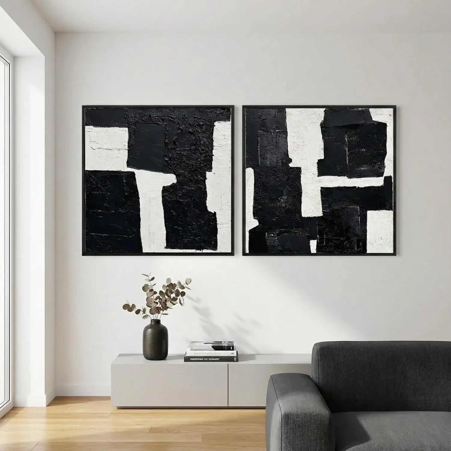 Modern living room with abstract black and white paintings on the wall.