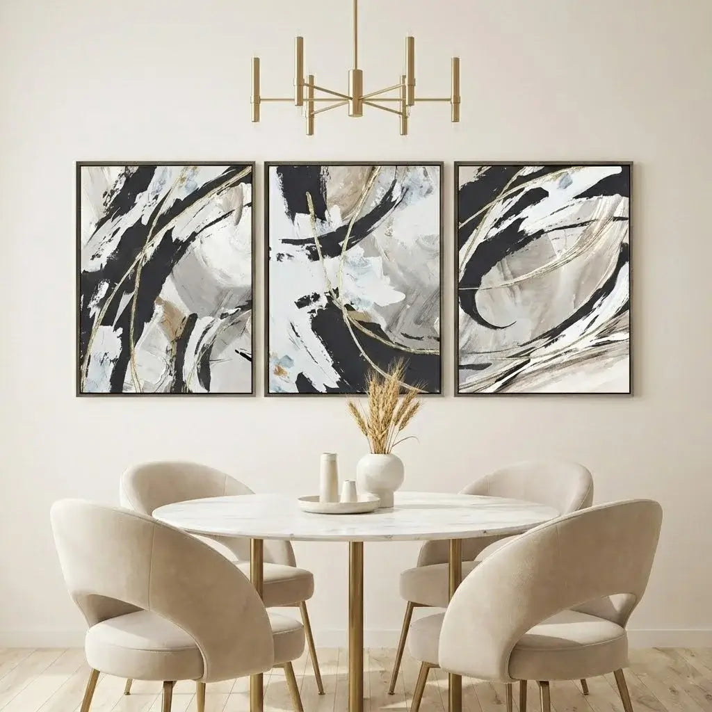 Dining room with a round table and chairs, abstract art on the wall, and a chandelier.