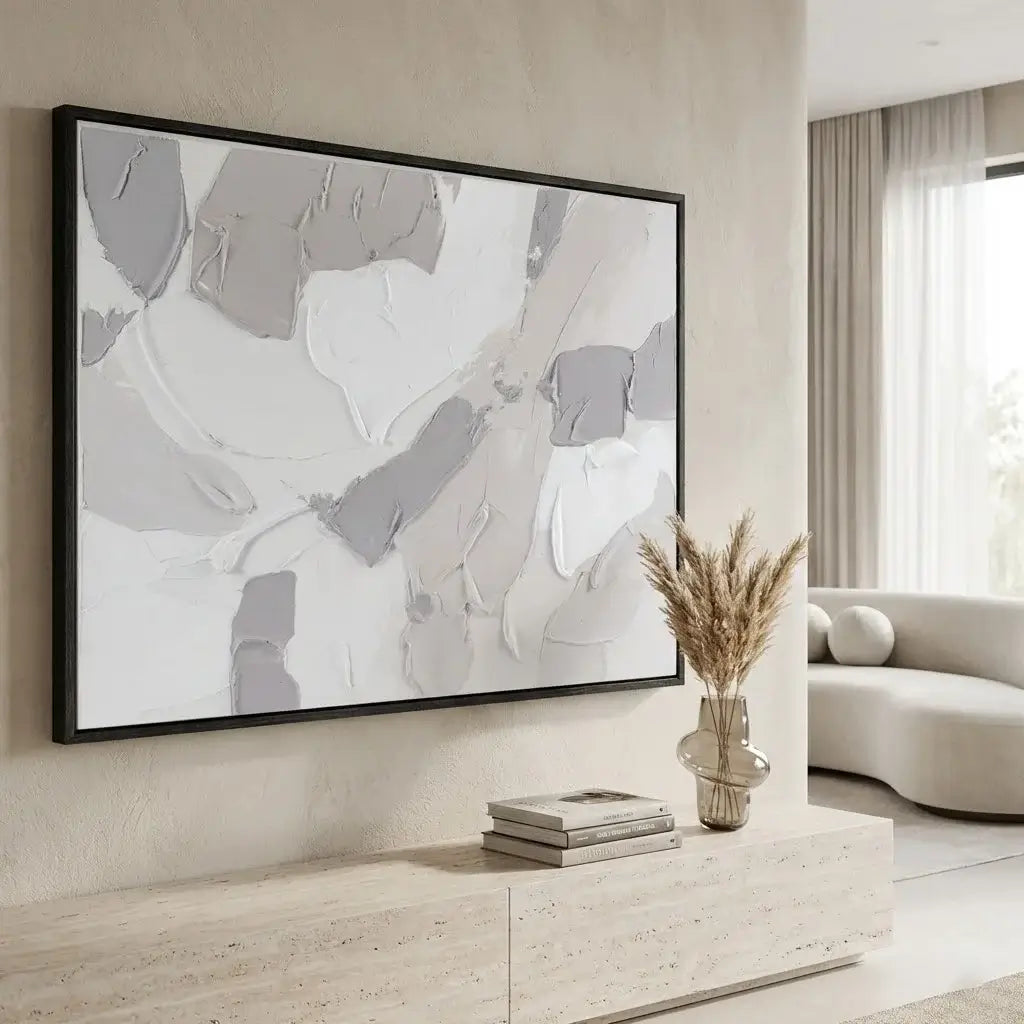 Abstract art piece in a modern living room setting with a vase and books on a console table.