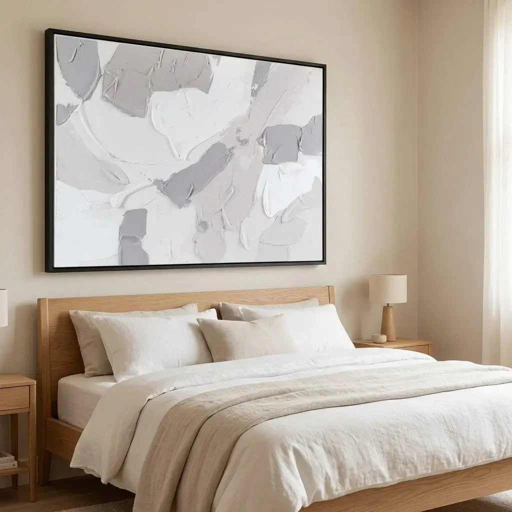 Neatly made bed with wooden headboard and abstract art on wall
