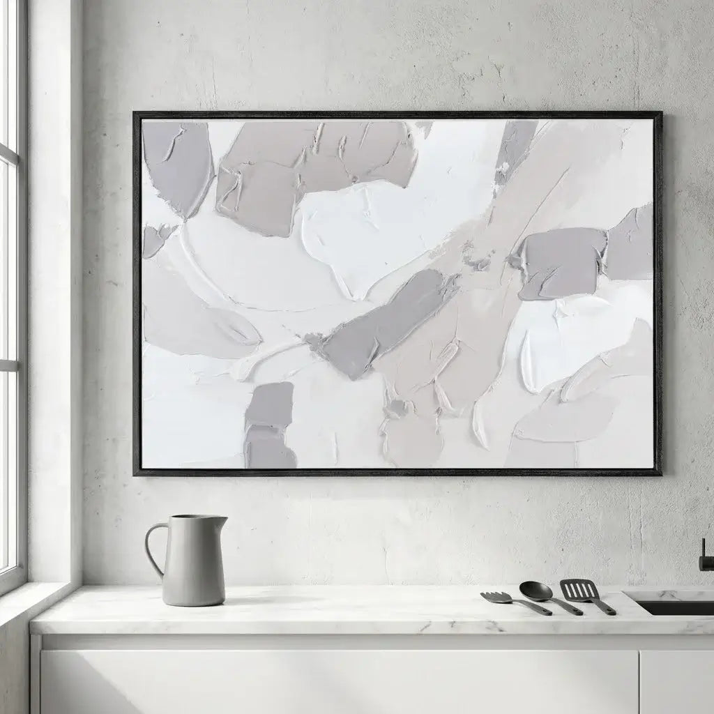Abstract art print in a black frame on a wall above a kitchen counter.