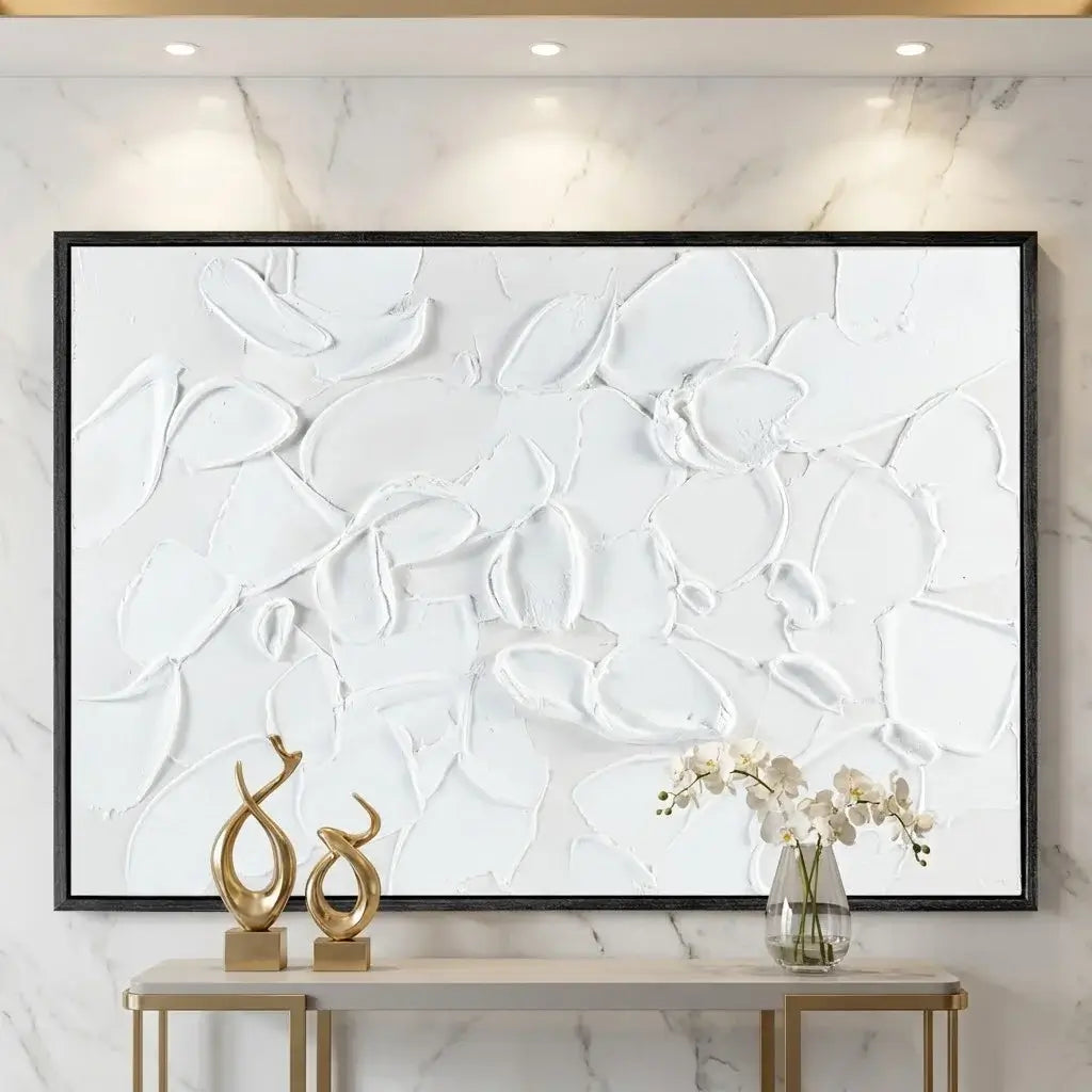 Abstract white artwork on a marble wall with decorative items below.