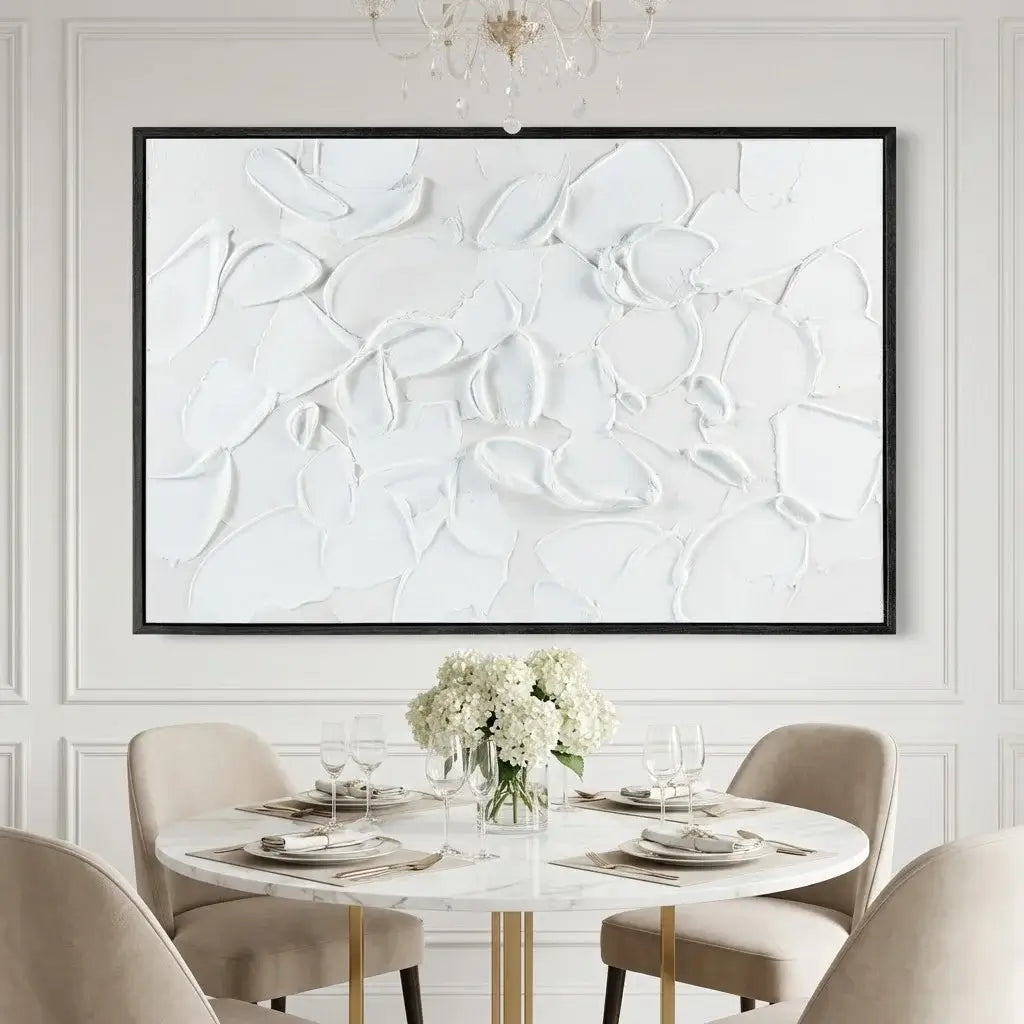 Dining room with a round table set for four, abstract wall art, and floral centerpiece.
