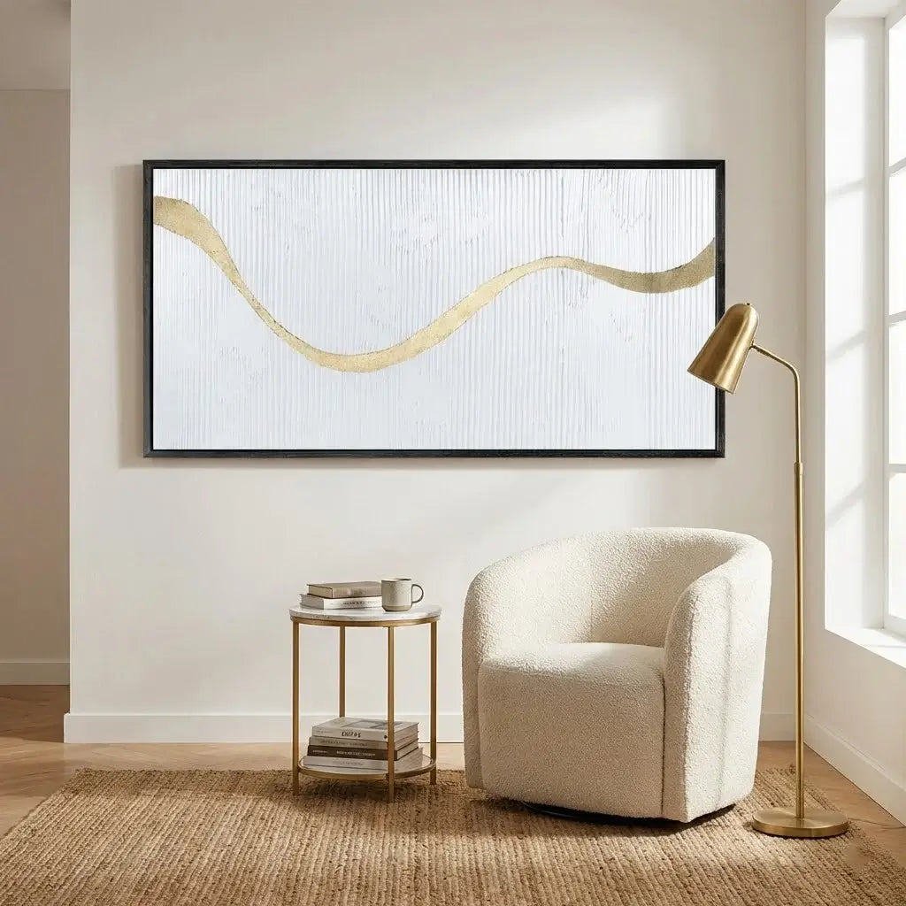 Modern living room with a white armchair, side table, and abstract wall art.