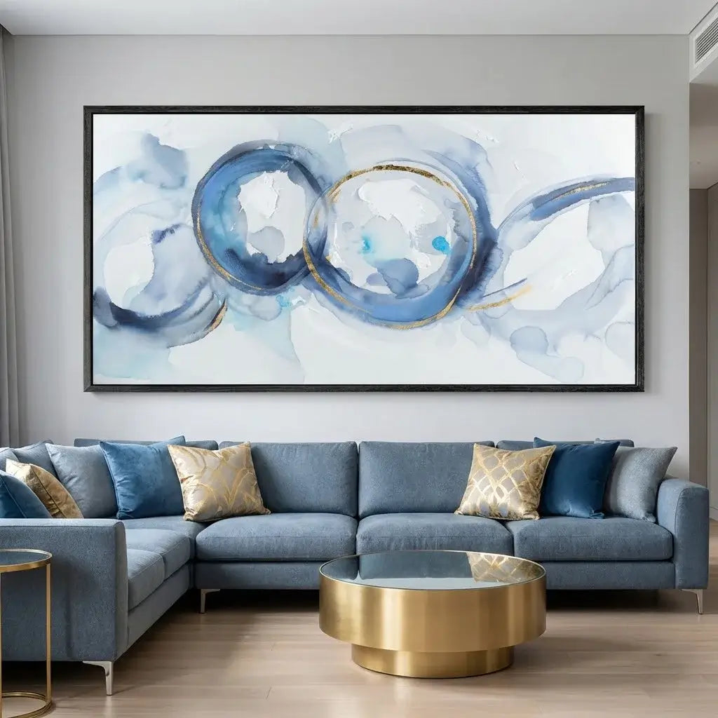 Living room with a blue sectional sofa, gold coffee table, and abstract art on the wall.