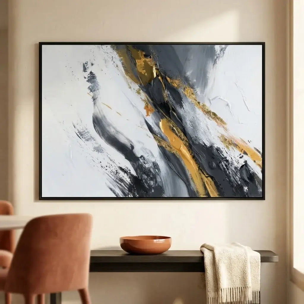 Abstract art painting with gold and black strokes on a wall above a dark sofa.