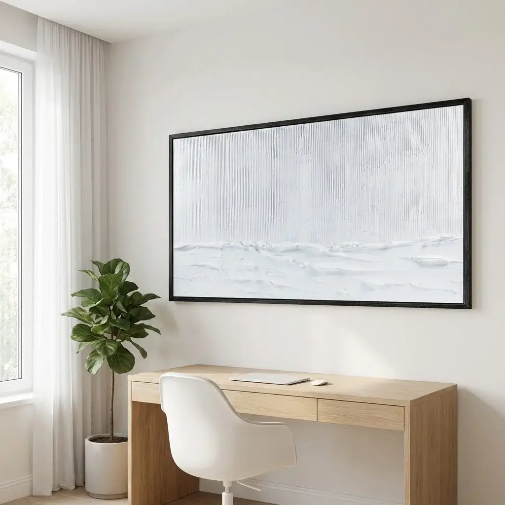 Modern home office with a desk, chair, and framed artwork on the wall.