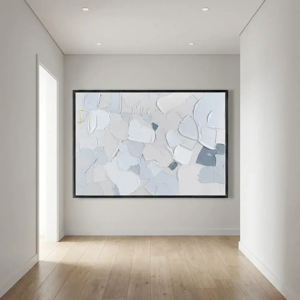 Abstract art piece on a wall in a minimalistic room with light wood flooring.