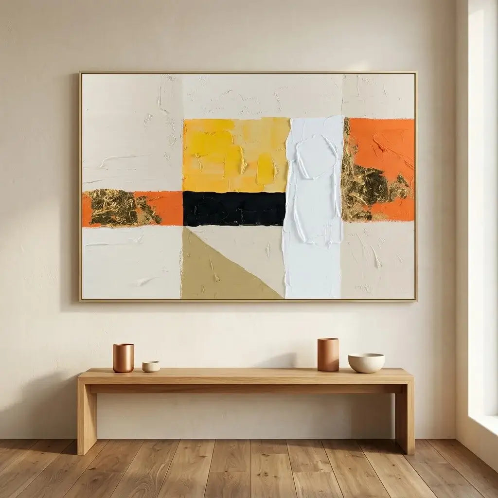 Abstract art piece with geometric shapes in orange, yellow, black, and white on a beige wall.
