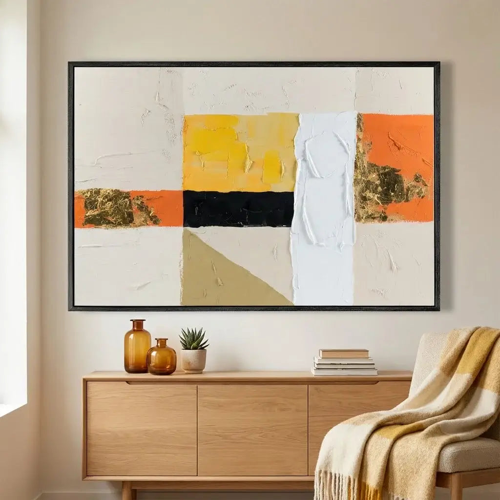 Abstract art piece on a wall above a wooden cabinet with decorative items.