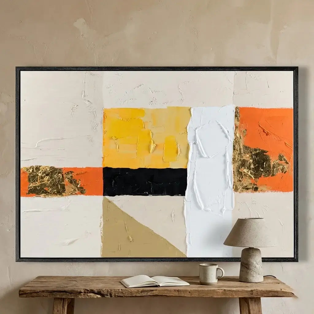 Abstract art piece with geometric shapes on a beige wall above a wooden table.