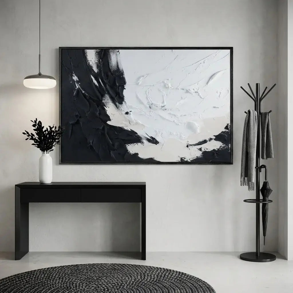 Modern interior with abstract black and white painting, console table, and coat rack.