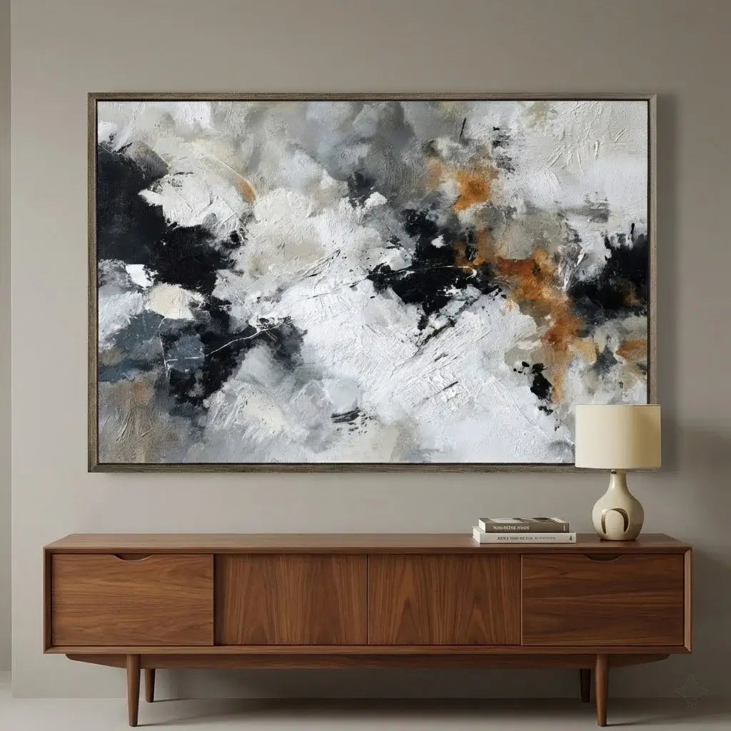 Abstract painting on a wall above a wooden console table with a lamp.