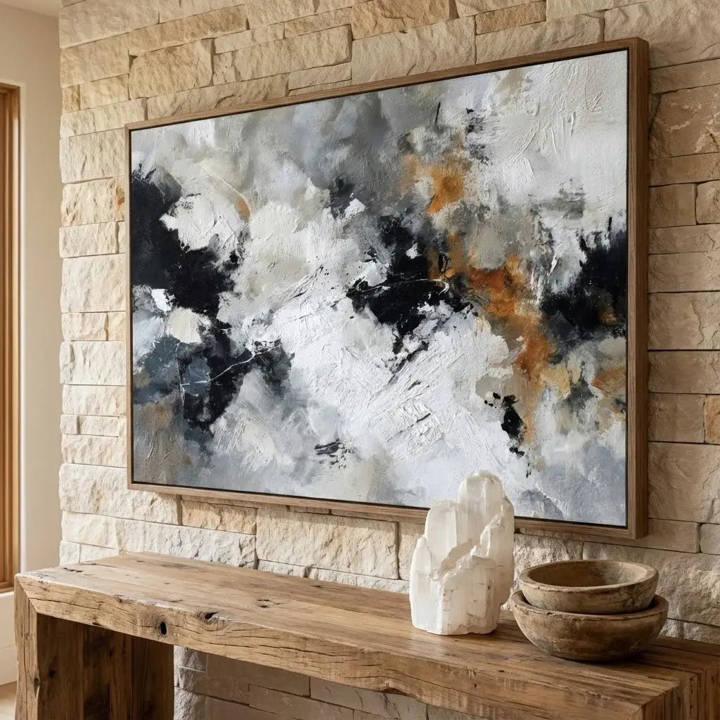Abstract painting on a stone wall above a wooden console table with decorative items.