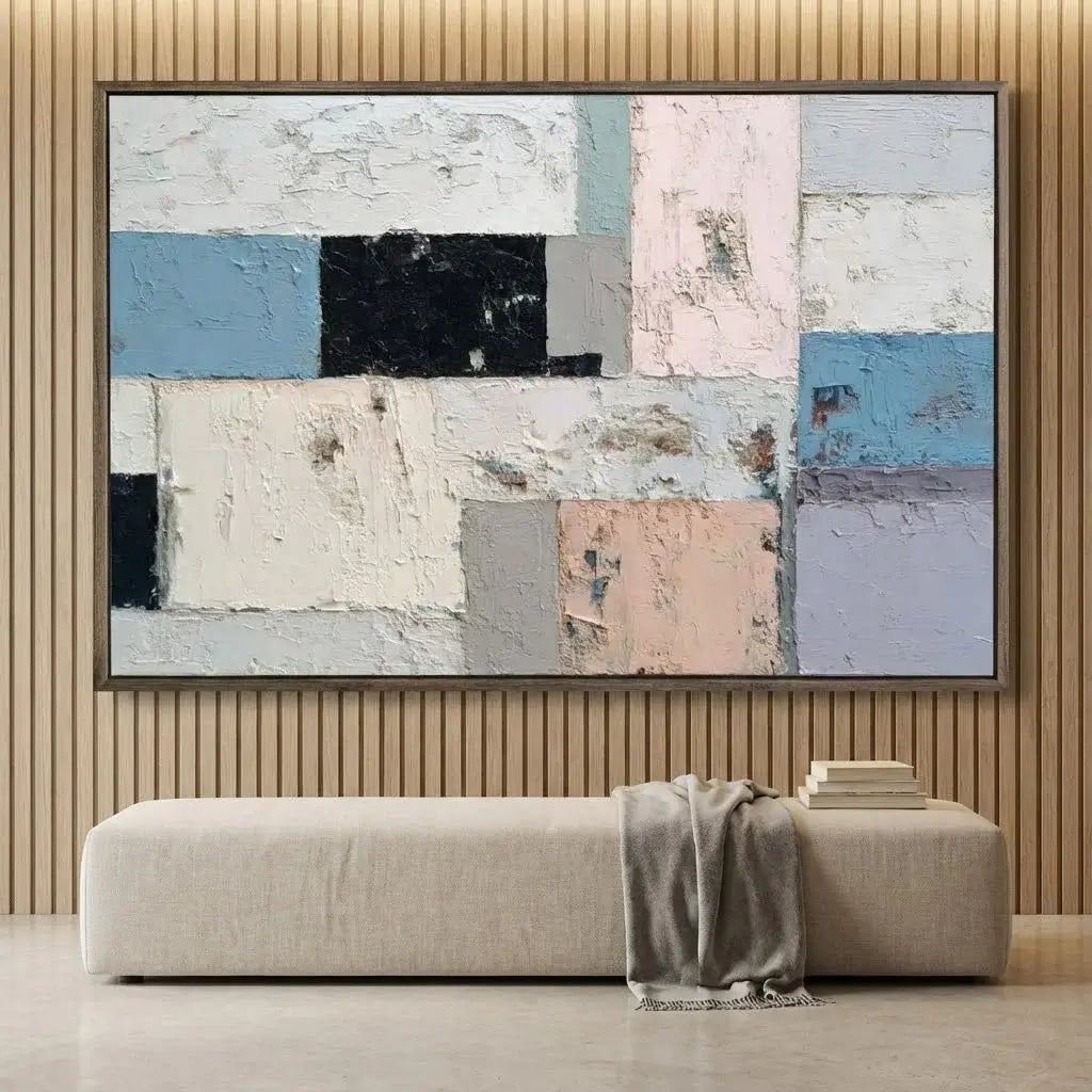 Abstract patchwork painting on a wall above a sofa.