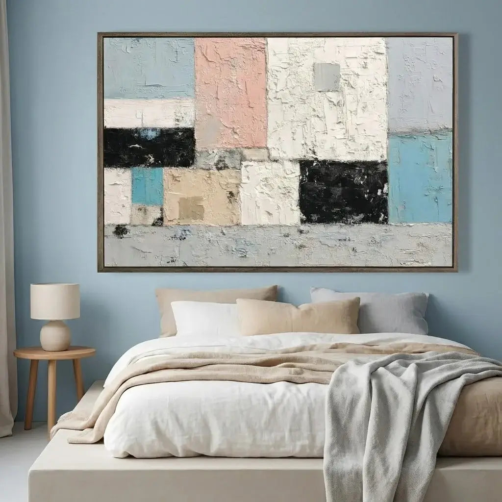 Abstract art piece on a wall above a bed in a bedroom.