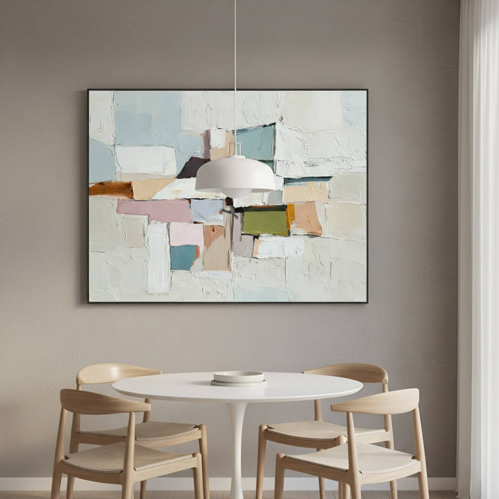 Abstract art piece on a wall above a dining table with chairs