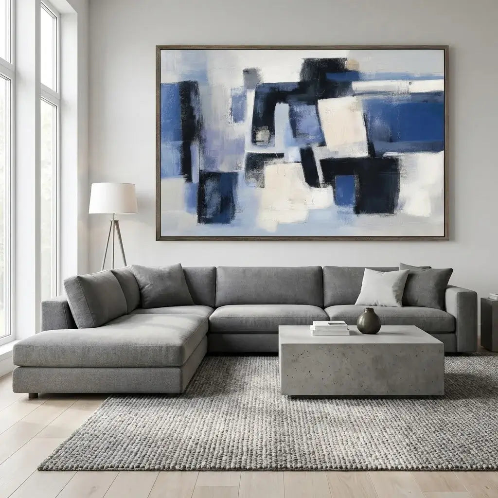 Modern living room with a gray sectional sofa, abstract painting, and concrete coffee table.