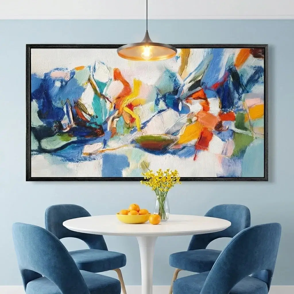 Colorful abstract painting in a modern dining room with blue chairs and a white table.