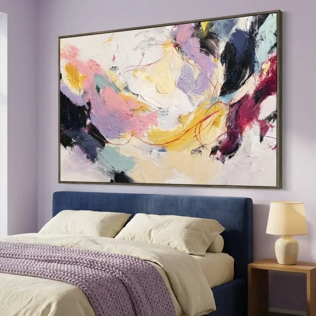 Abstract painting on a wall above a bed with a nightstand and lamp.