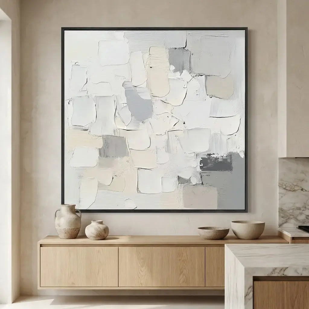 Abstract art piece on a wall above a wooden console table with decorative bowls.