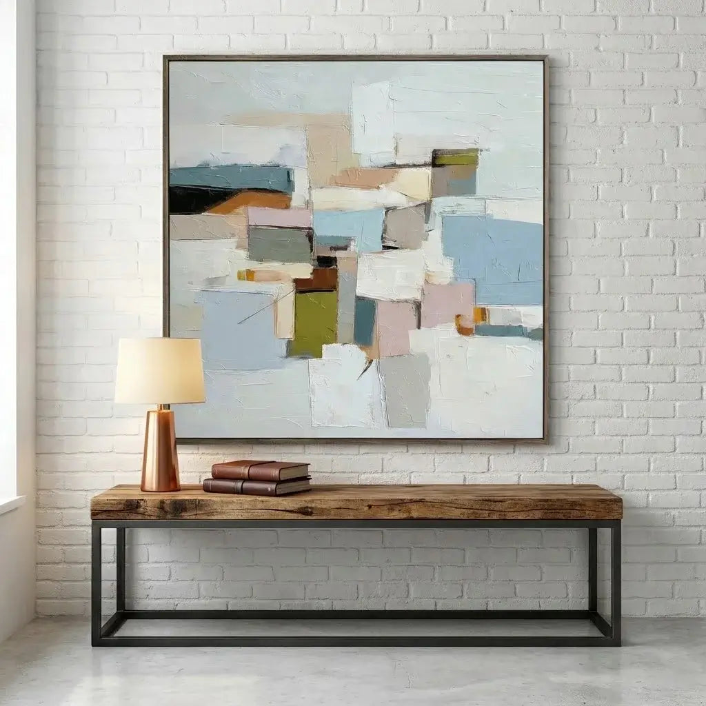 Abstract painting on a white brick wall above a wooden console table.