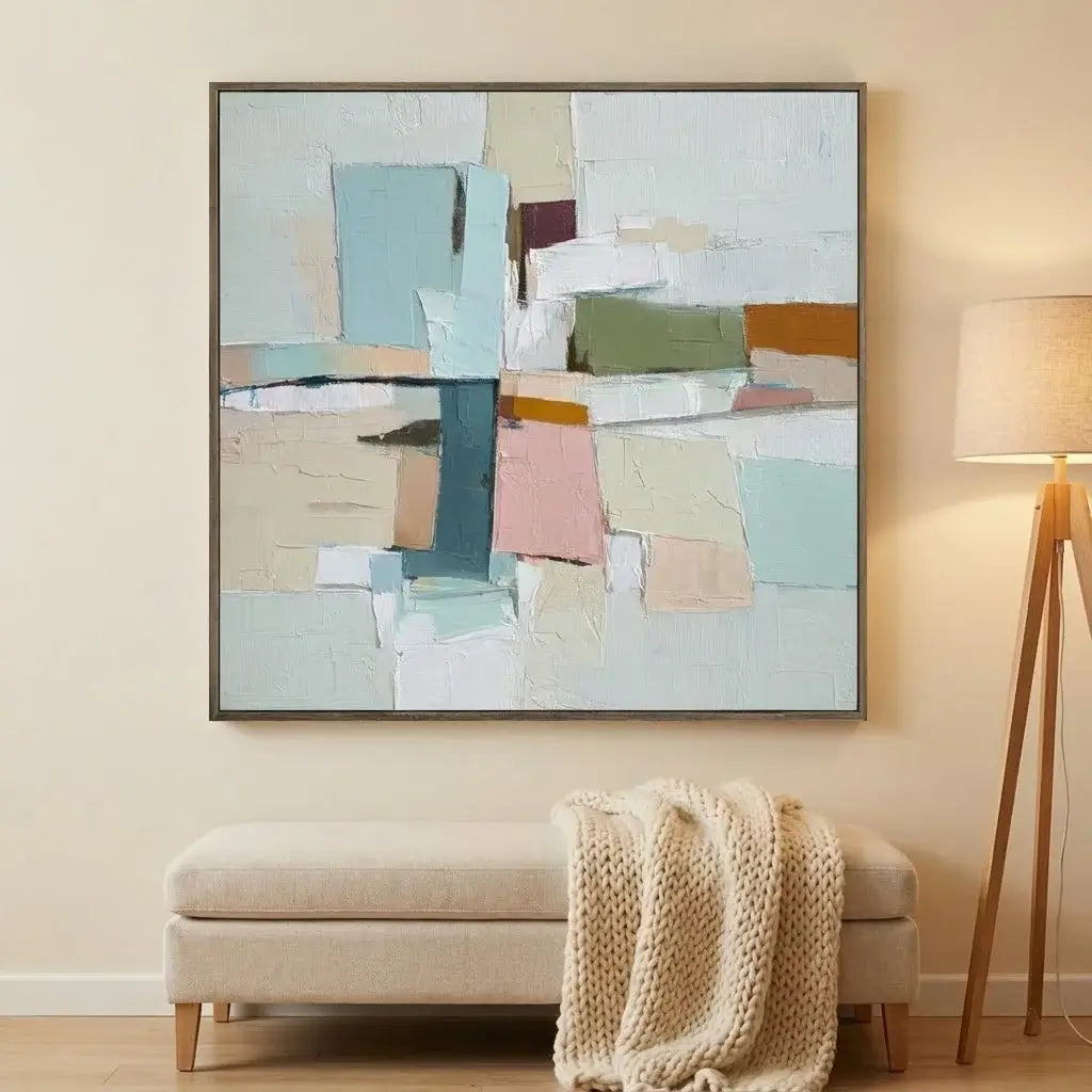 Abstract art piece on a wall above a bench with a blanket