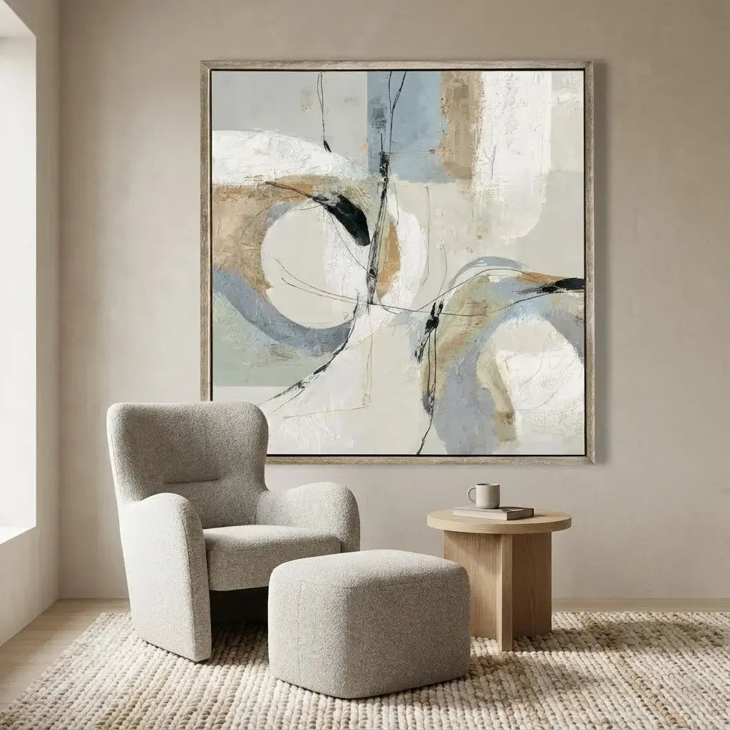 Modern living room with abstract art, gray armchair, and wooden table.