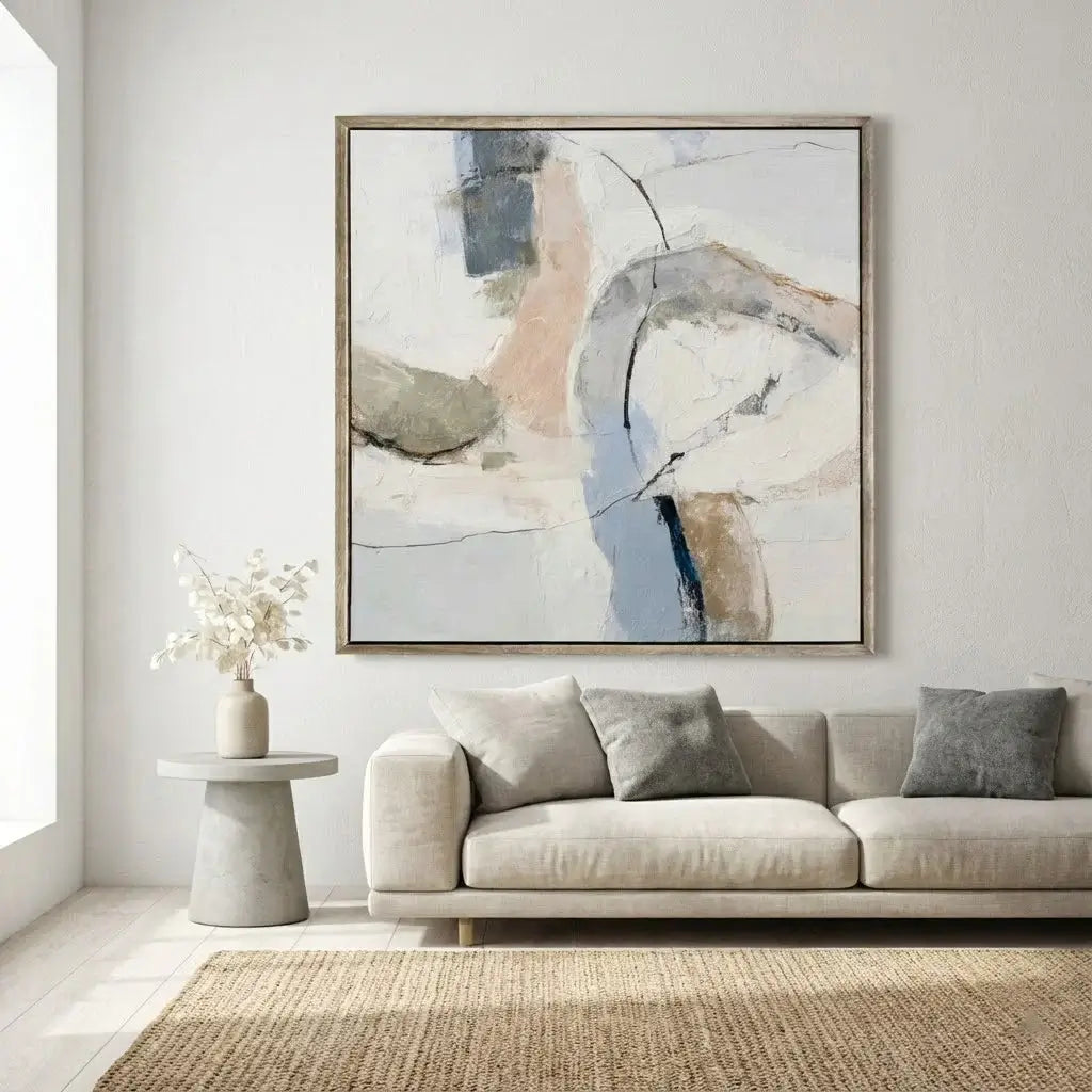 Modern living room with a beige sofa, abstract painting, and side table.