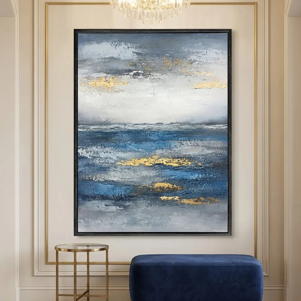 Abstract painting with blue and gold tones on a wall above a blue chair.