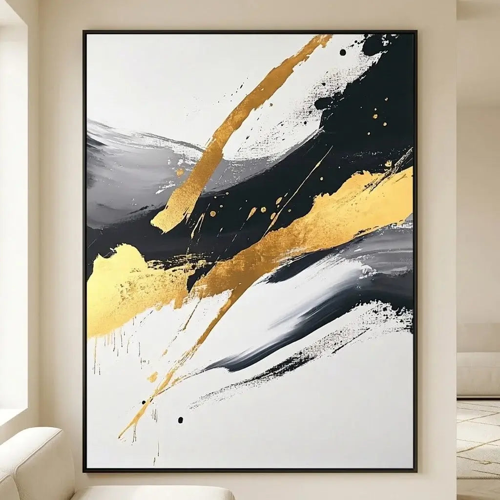 Abstract art piece with gold and black splashes on a wall in a modern interior setting.