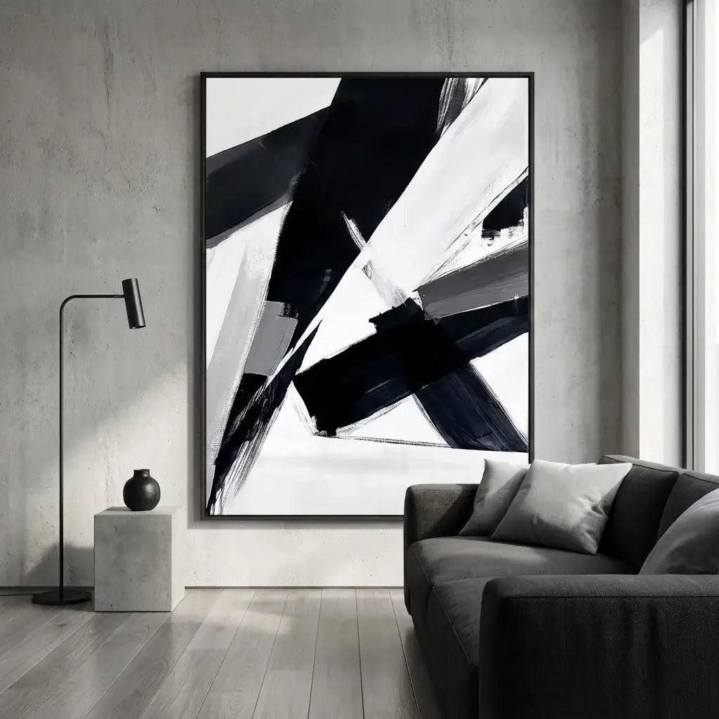 Abstract black and white painting in a modern living room with a gray sofa and floor lamp.