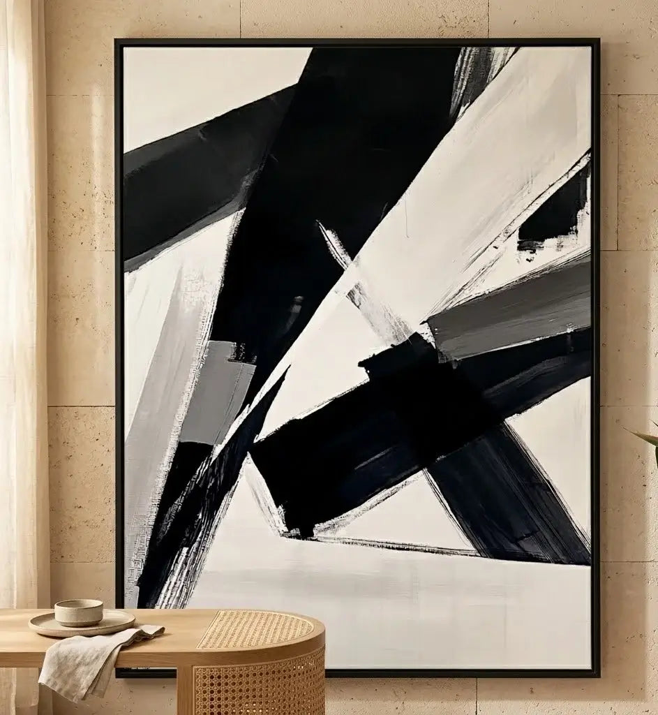 Modern interior with a black and white abstract painting on a gray wall, a black dining table, and bar shelves with bottles.