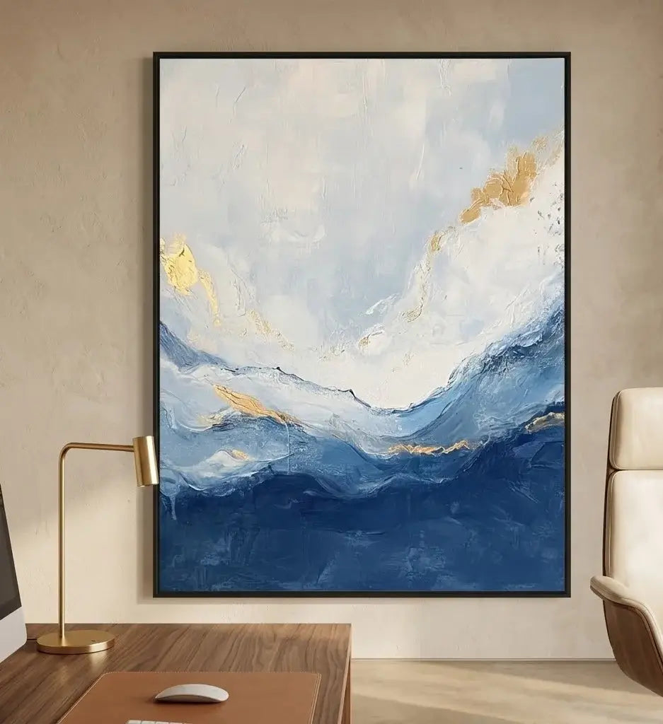 Abstract painting on a wall above a brown leather chair in a room with wooden shelves.