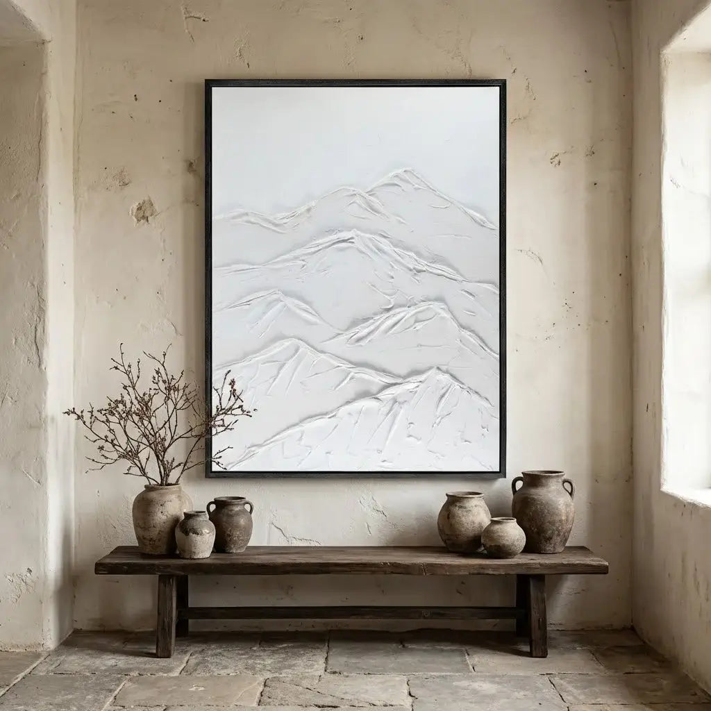 Framed abstract mountain art on a textured wall with decorative vases below.