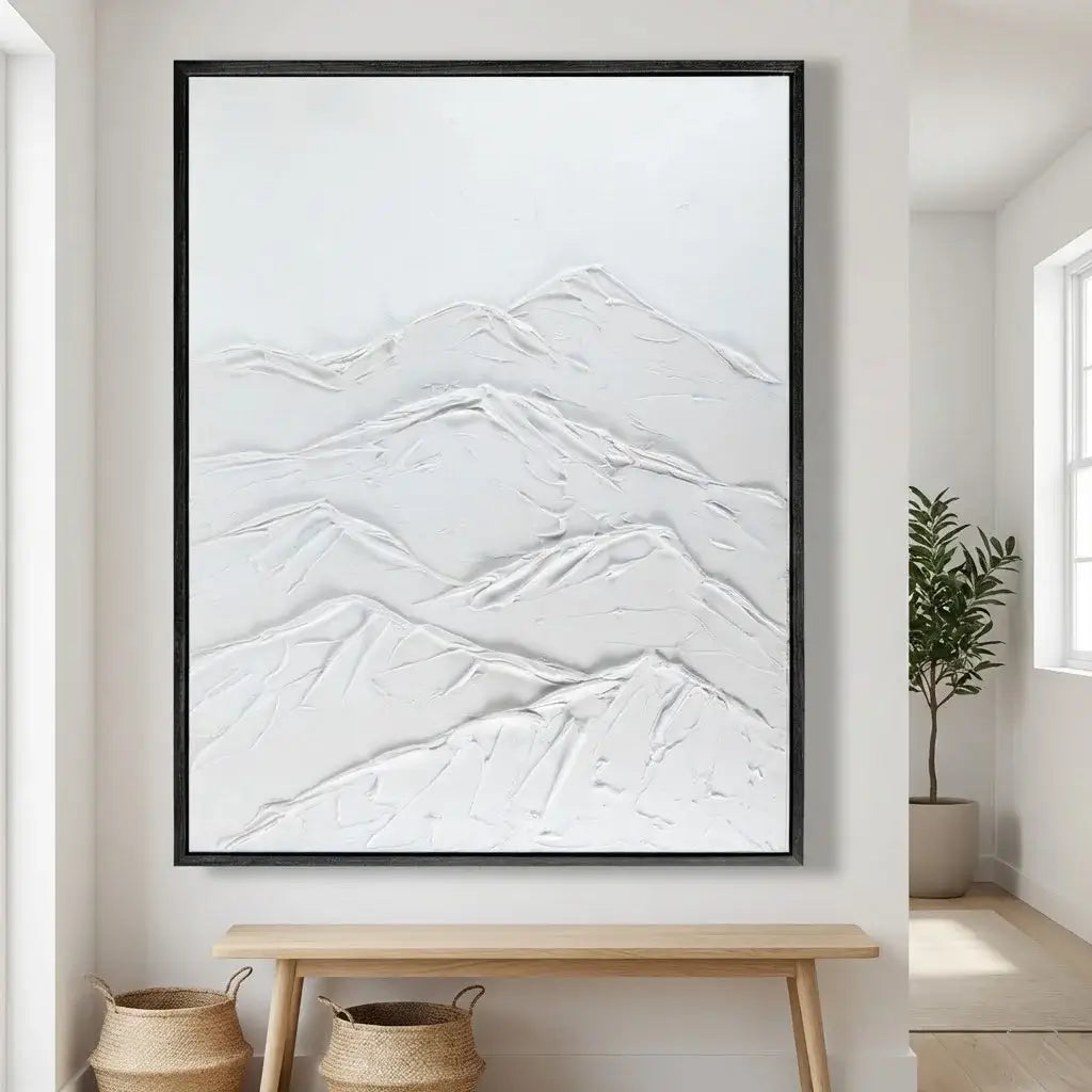 Framed abstract mountain artwork on a wall in a room with a wooden bench and plant.