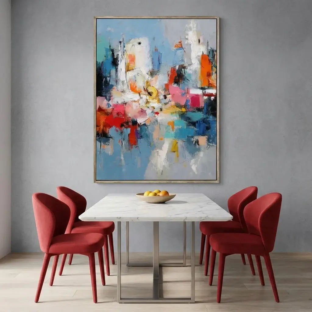 Dining room with red chairs, marble table, and abstract painting on gray wall