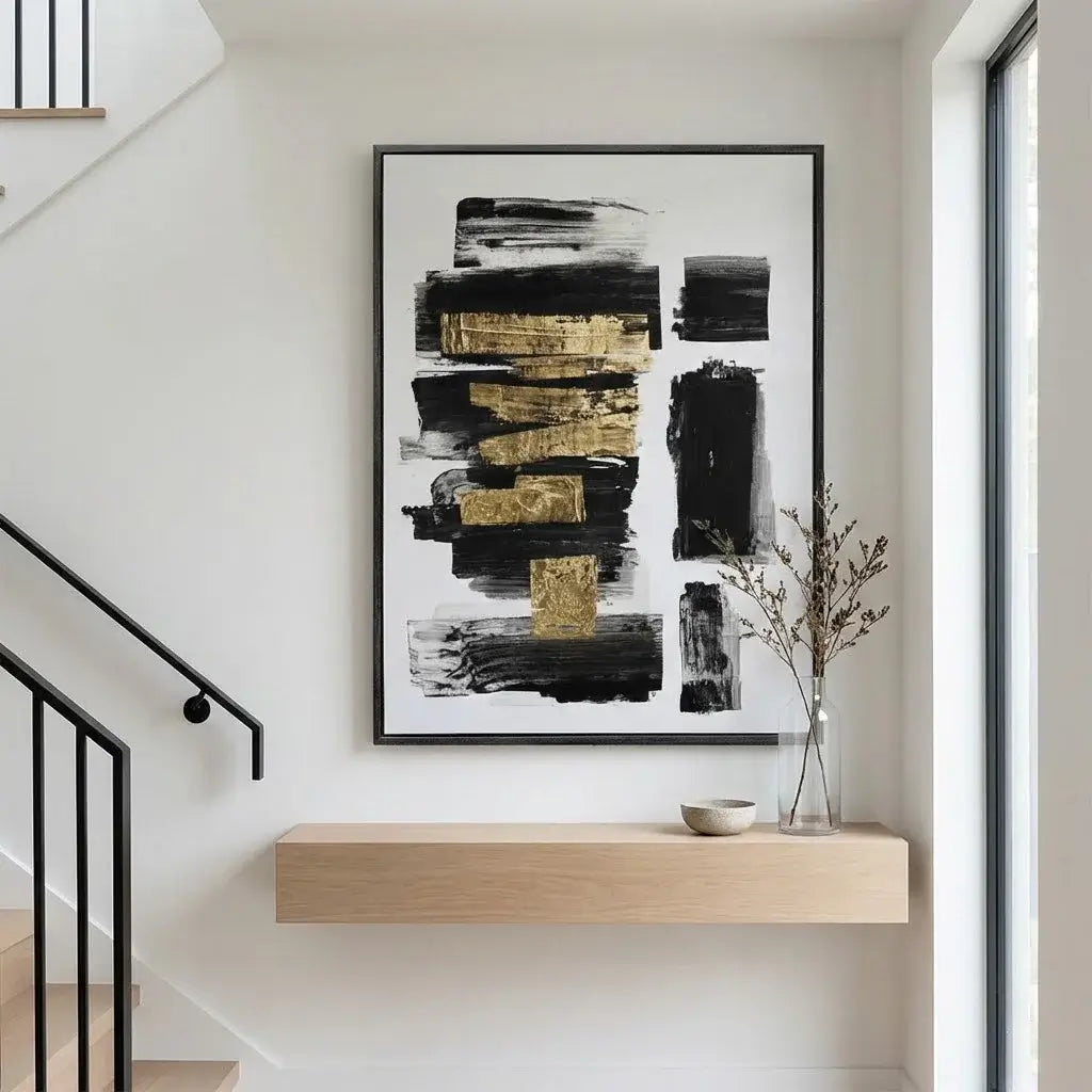 Abstract art piece with black and gold tones in a modern interior setting.