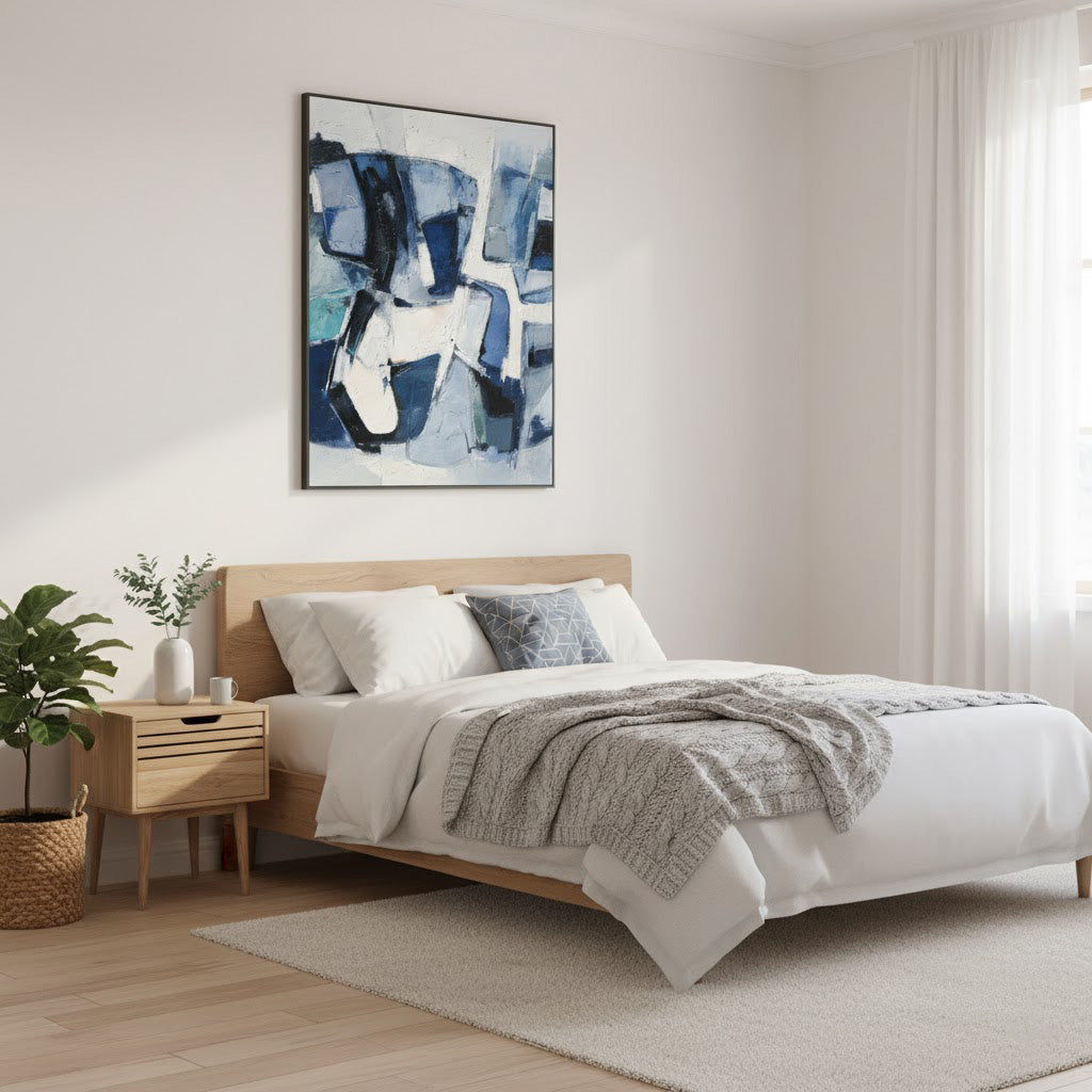 Modern bedroom with a bed, abstract art on the wall, and a side table.