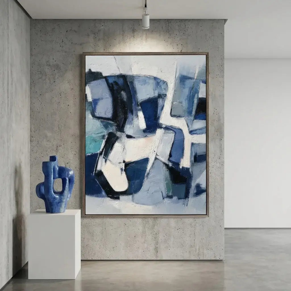 Abstract blue and white painting on a gray wall with a blue sculpture on a white pedestal.