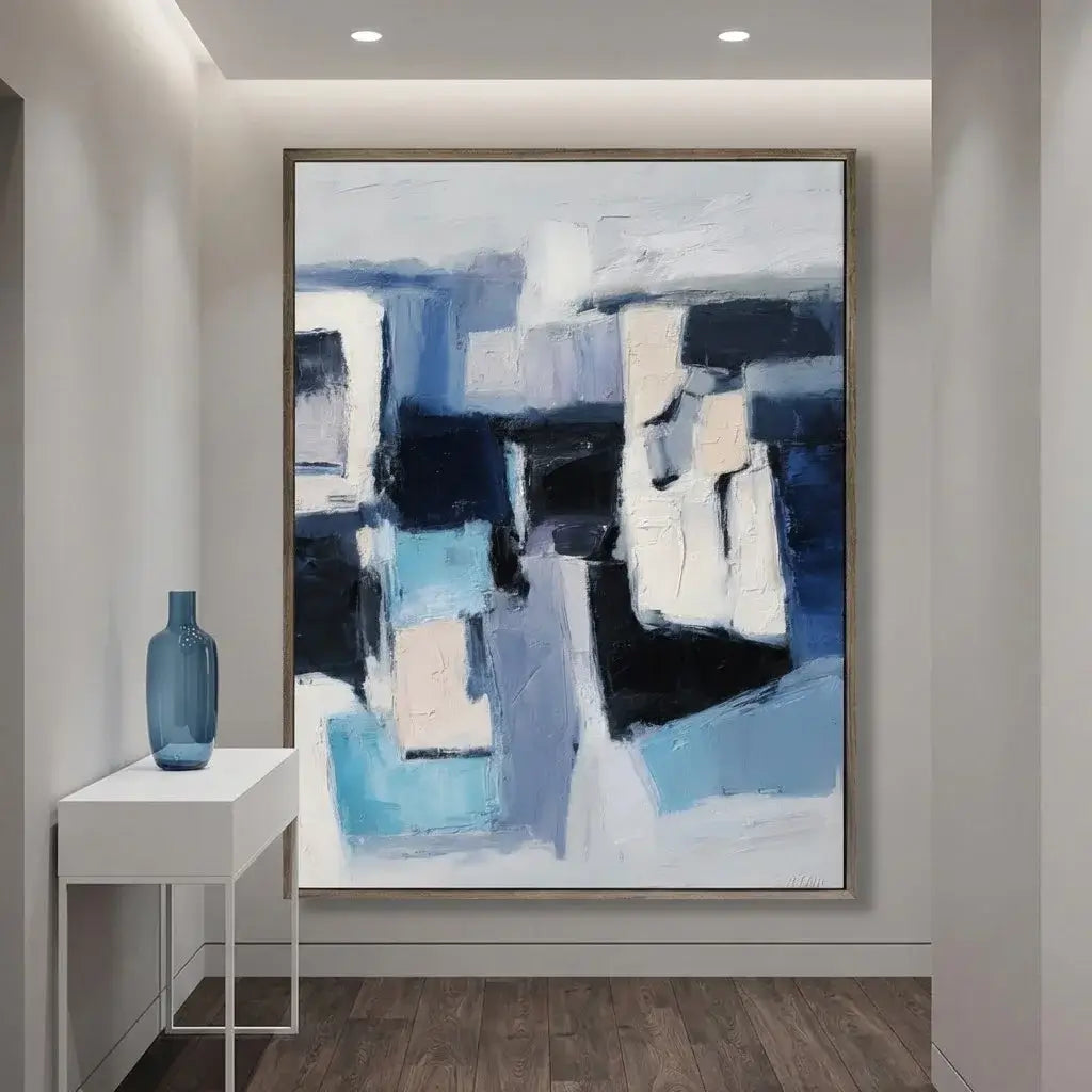 Abstract painting in a modern interior setting with a blue vase on a side table.