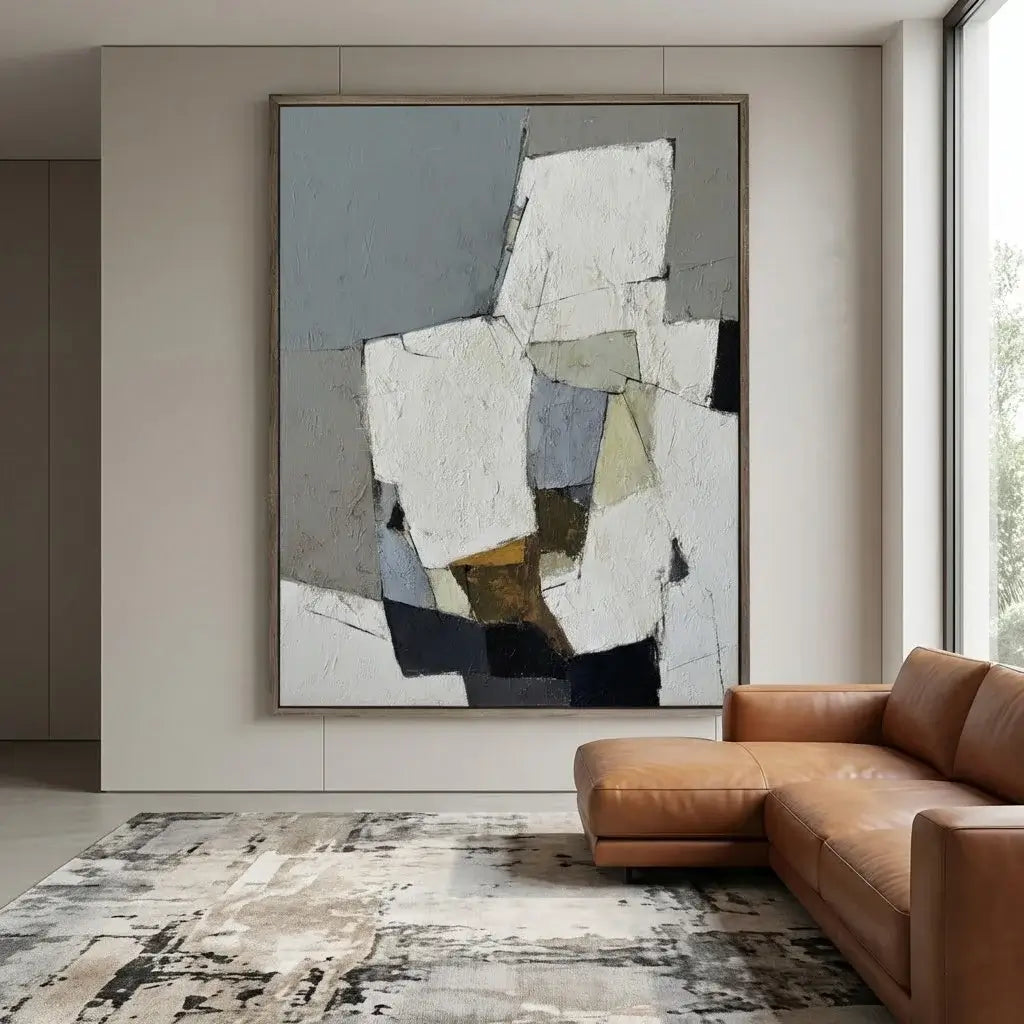 Abstract painting on a wall above a brown leather sofa in a modern living room.