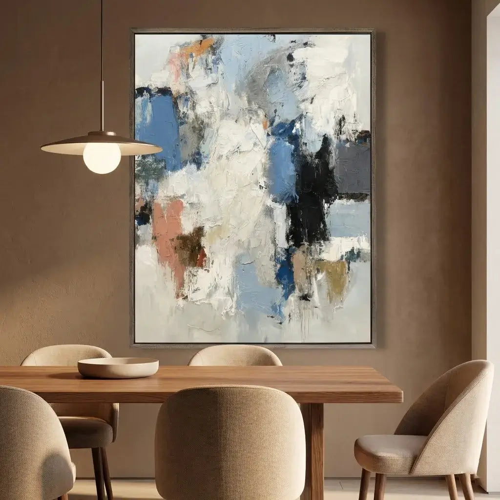 Abstract painting on a wall above a dining table with chairs.