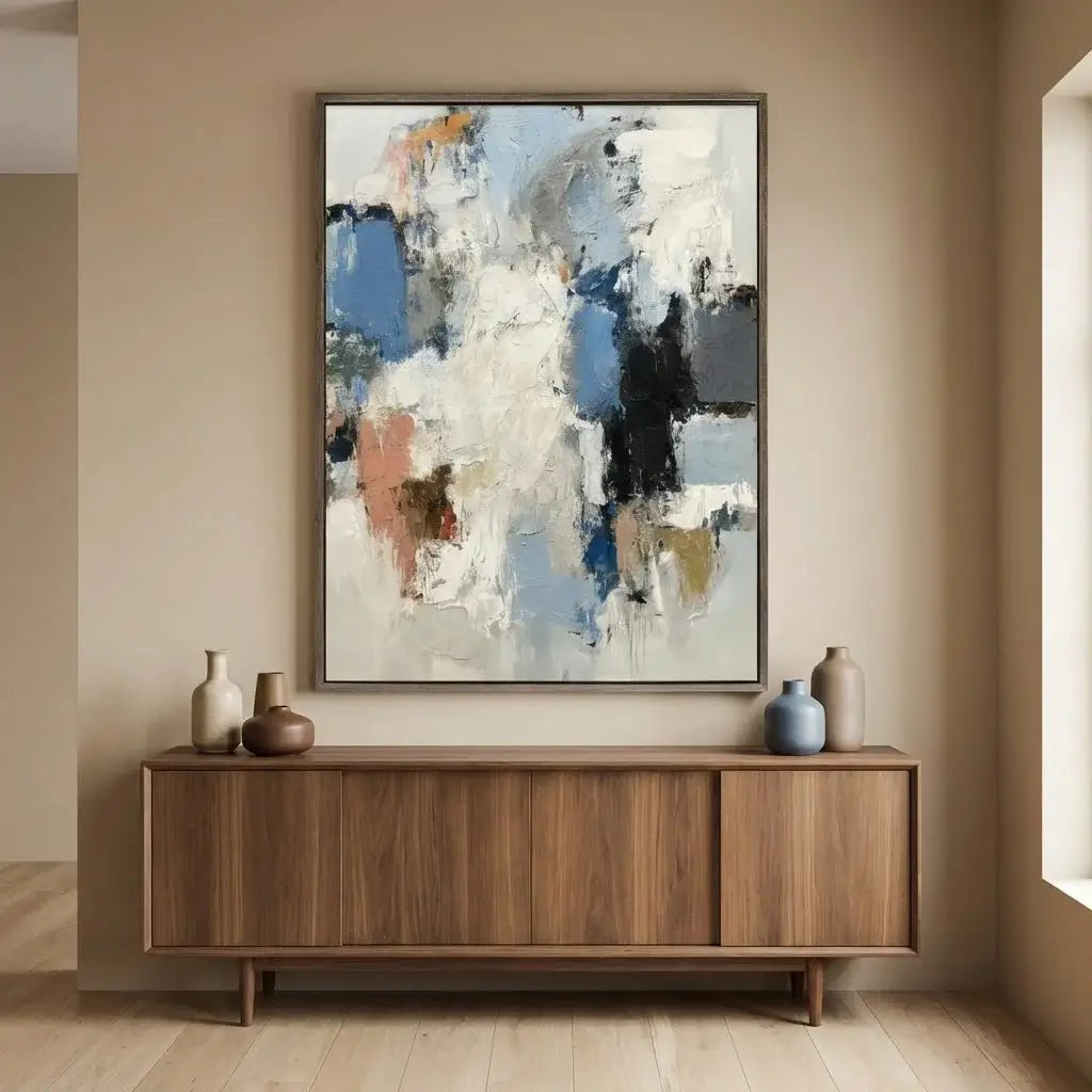 Abstract painting on a wall above a wooden cabinet with decorative vases.