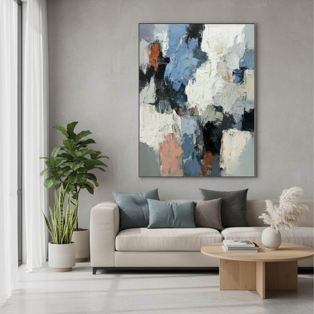 Modern living room with a abstract painting on the wall, sofa with cushions, and a plant.